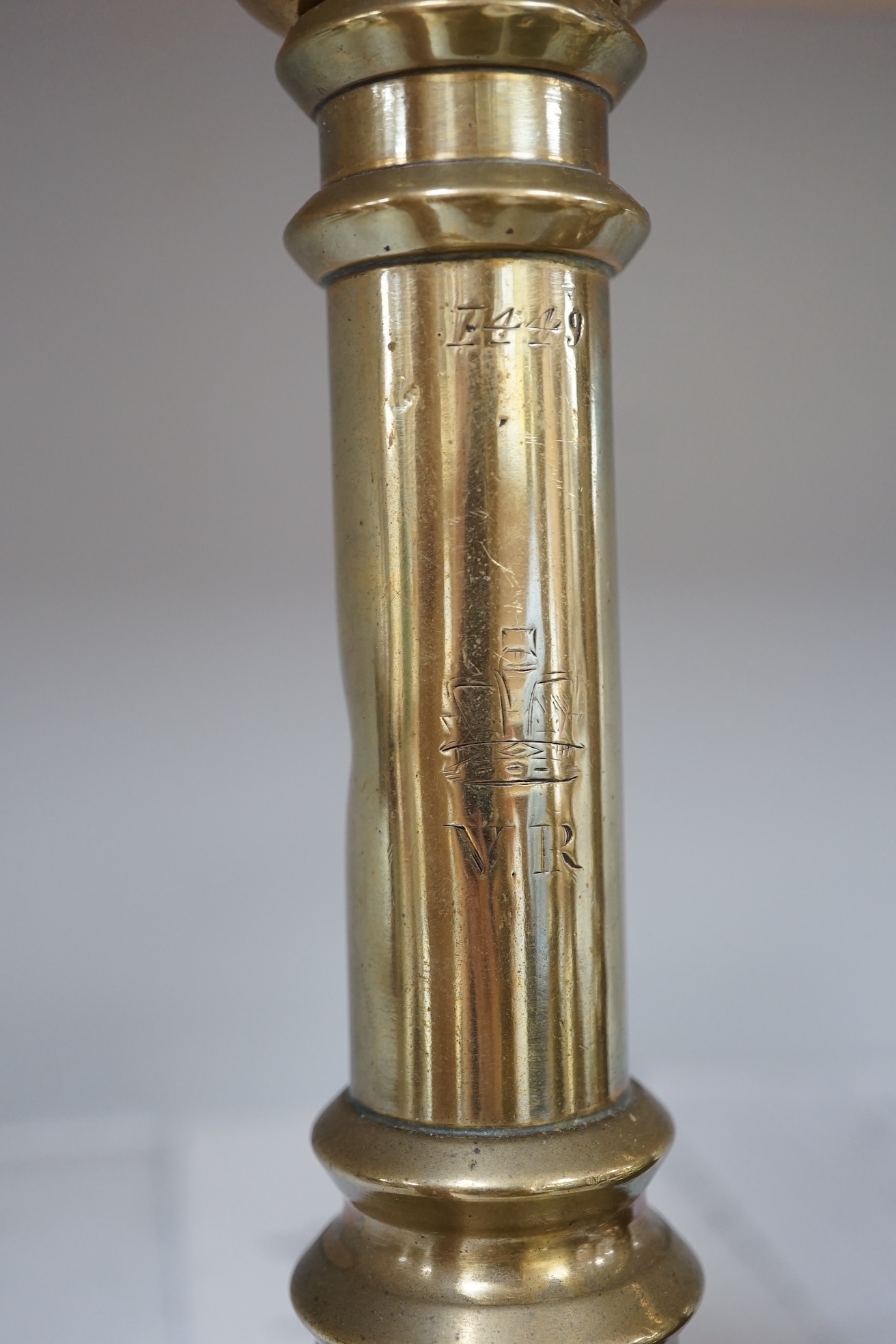 Six Victorian/William IV government issue brass candlesticks, five engraved with cipher crown and number 21.5cm high. Condition - fair.